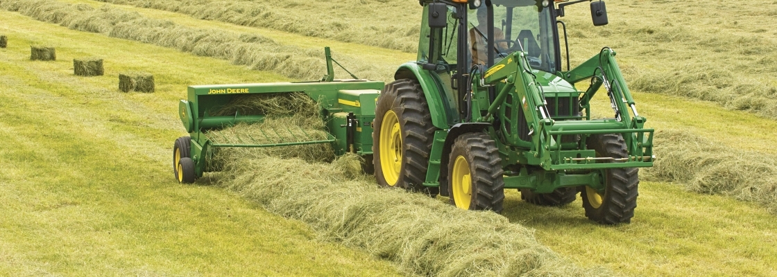 Tractor picking up hay